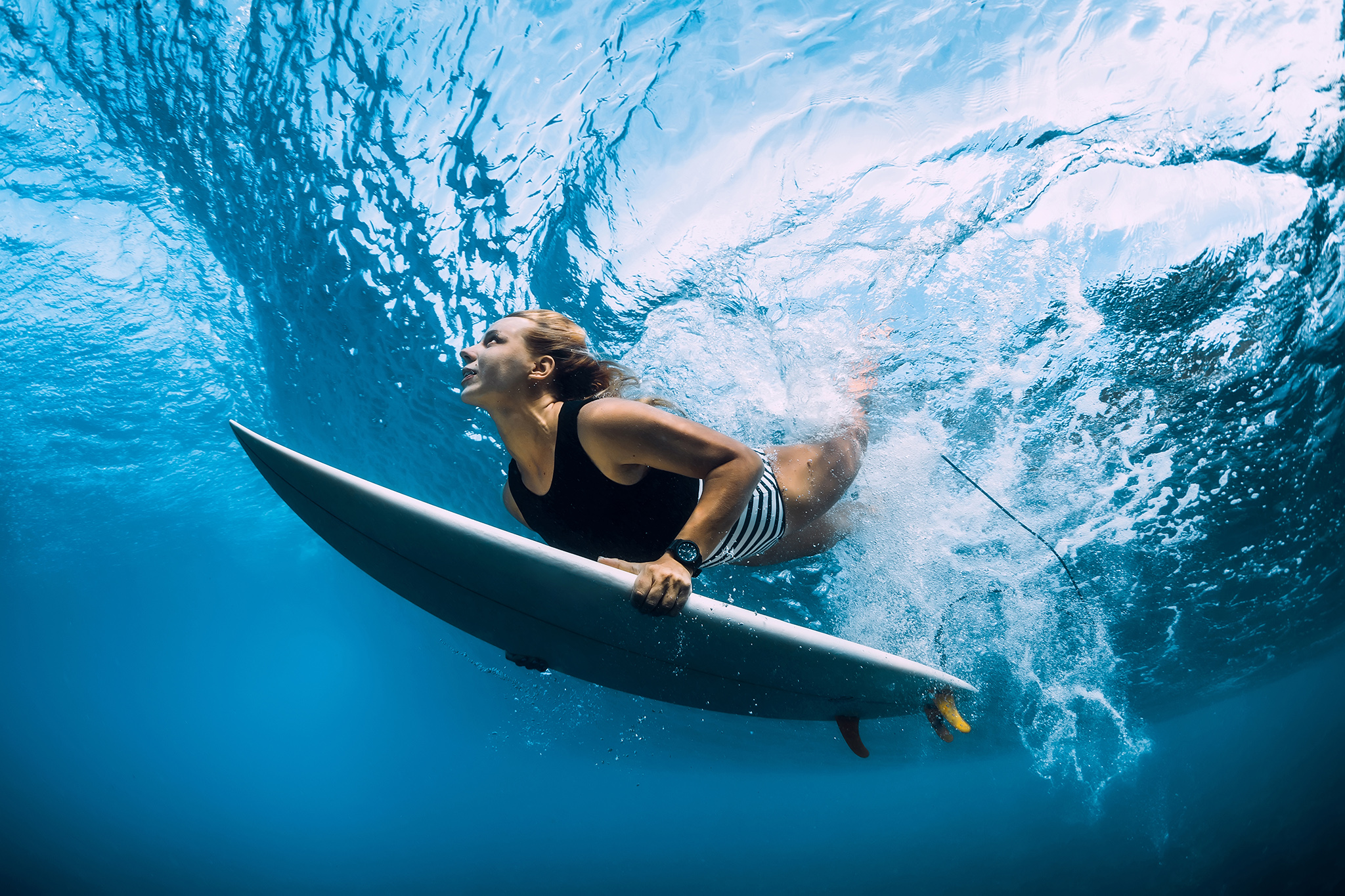 Surfer woman dive underwater. Surfgirl dive under big wave